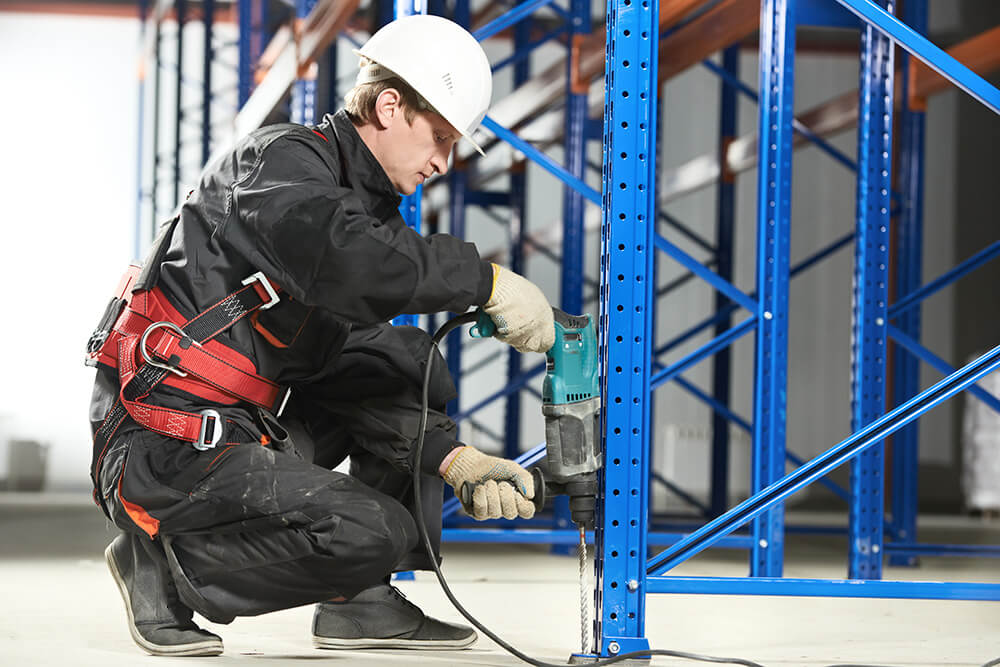 Installer anchoring a racking upright during teardown and relocation work